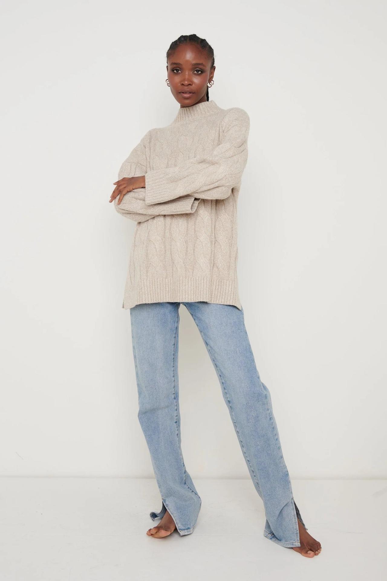 Model wearing a cable knit roll jumper