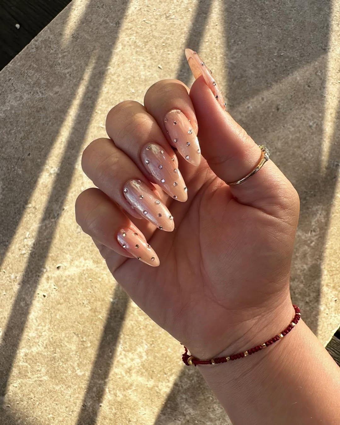 Chrome and crystal manicure on long almond shape nails