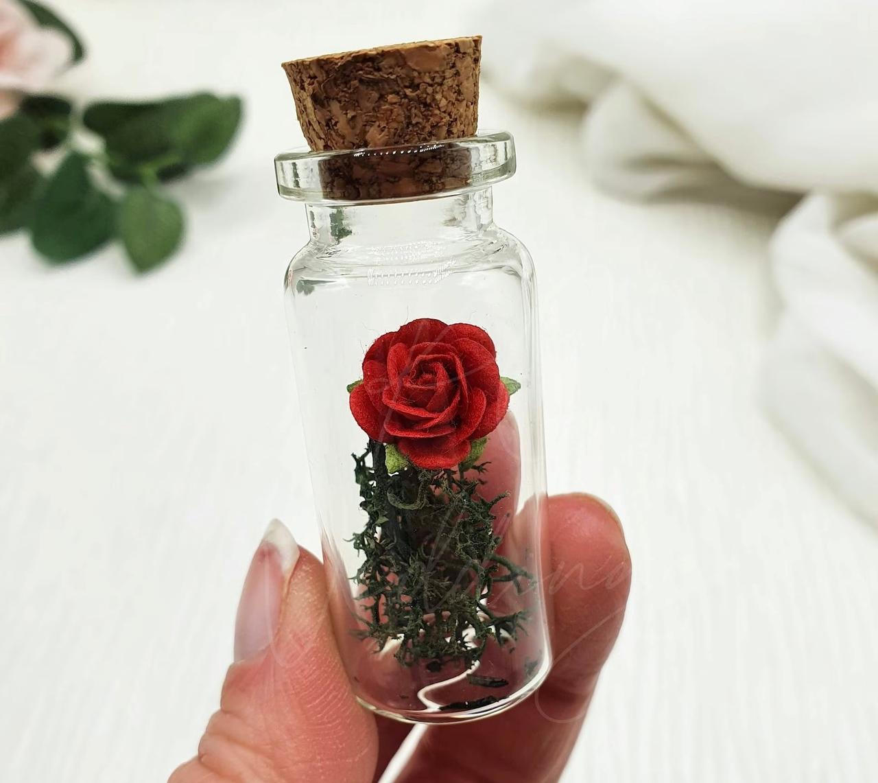Glass jar wedding favour with a red rose inside