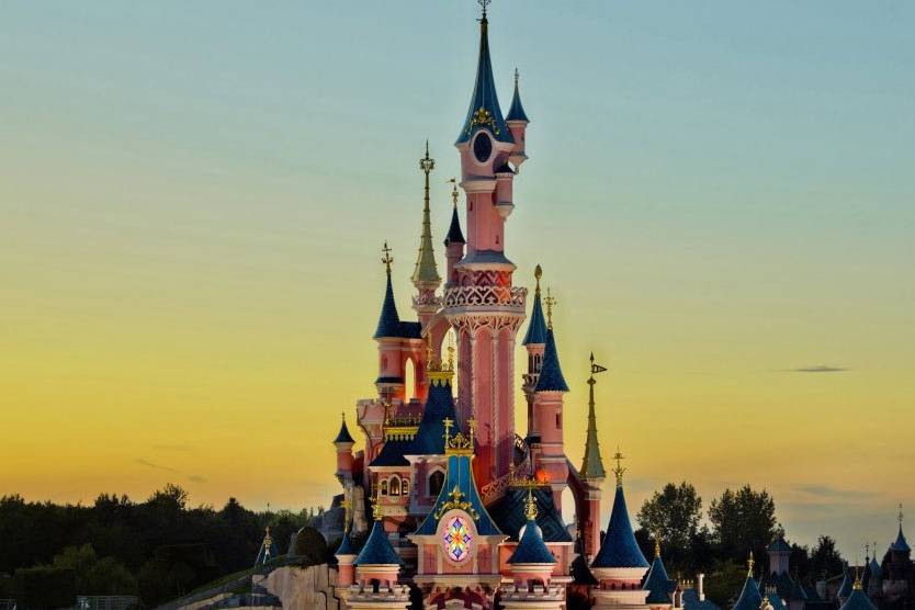 Disney castle against a colourful sky