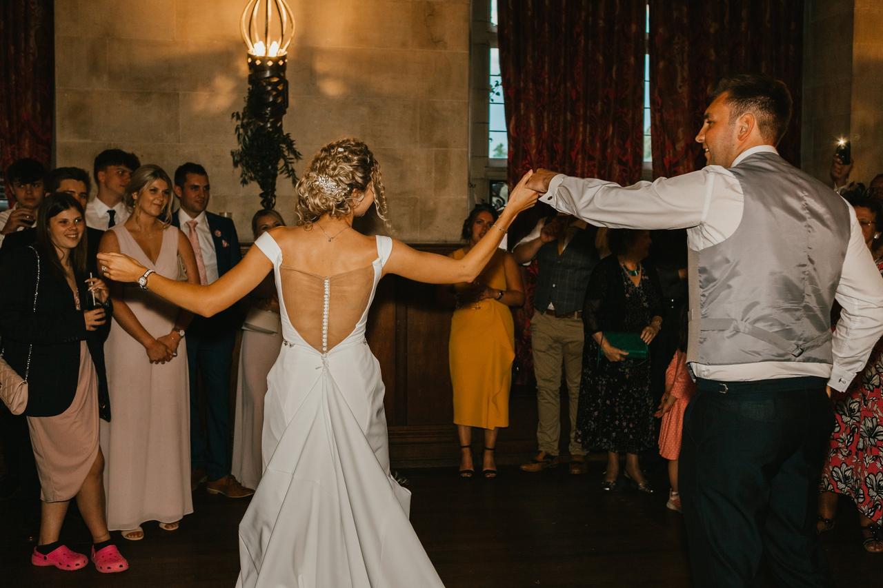 The bride and groom perform their first dance as the guests watch on