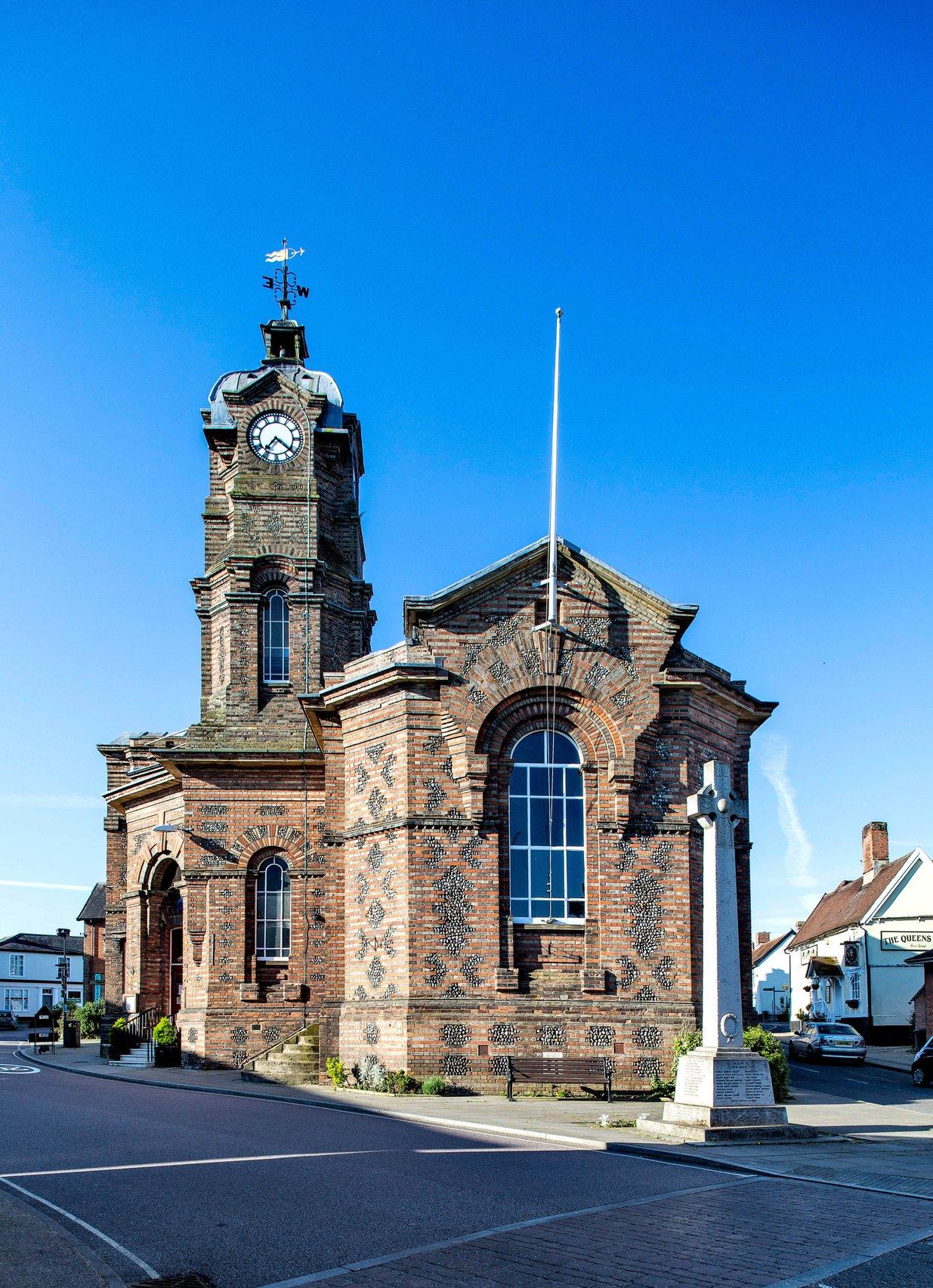 Exterior of an old town hall building in a Suffolk village against a blue sky.