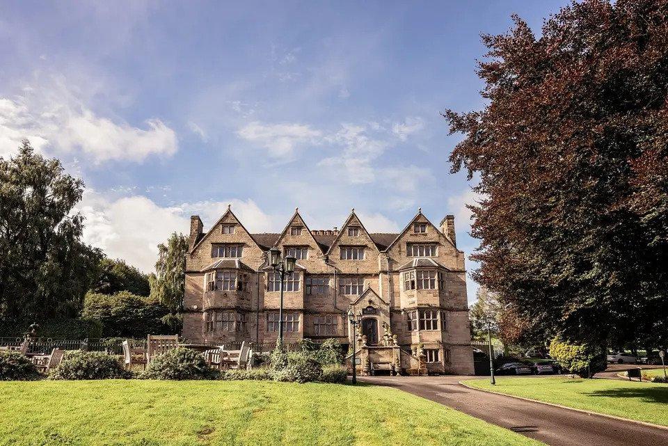 Exterior of Weston Hall photographed from across the lawn with trees and lamplights