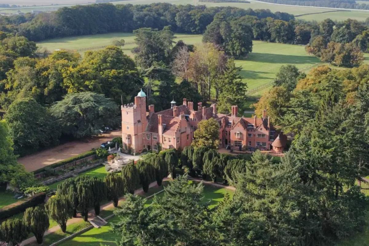 Suffolk wedding venue Lanwades Hall photographed from above with trees and gardens surrounding it