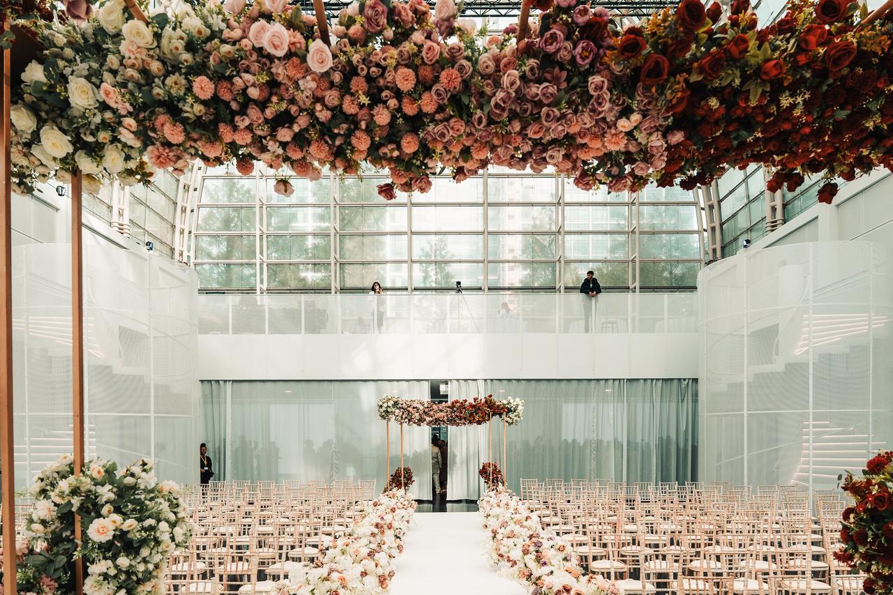Interior of a glass atrium-style wedding venue set up for a ceremony.