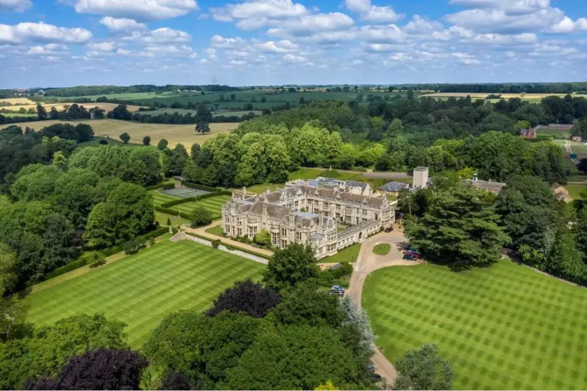 an overhead drone shot of hotel wedding venue rushton hall surrounded by greenery and countryside
