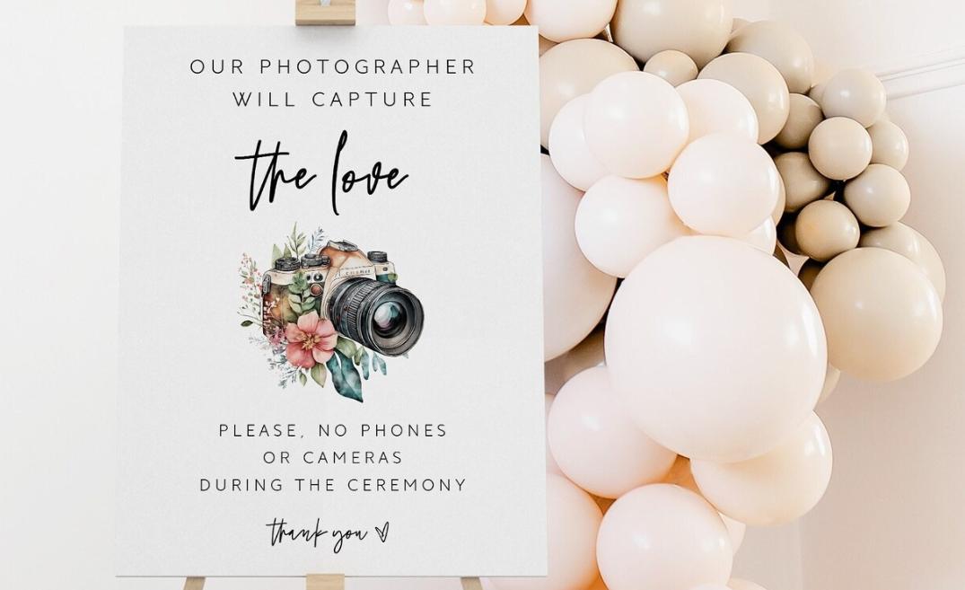 136455 An Unplugged Wedding Ceremony Sign With A Camera And Floral Illustration Sat On An Easel With Pastel Pink Balloons In The Background 
