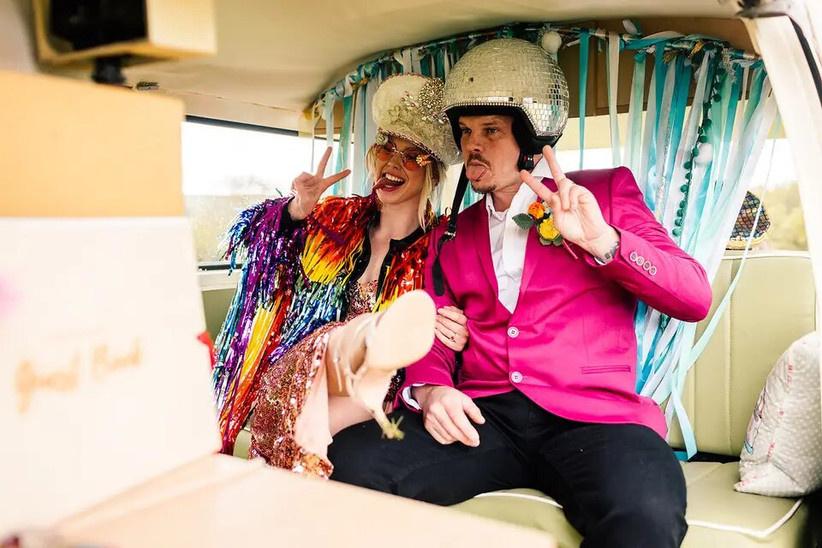 Couple in fancy dress making faces in a camper van photo booth