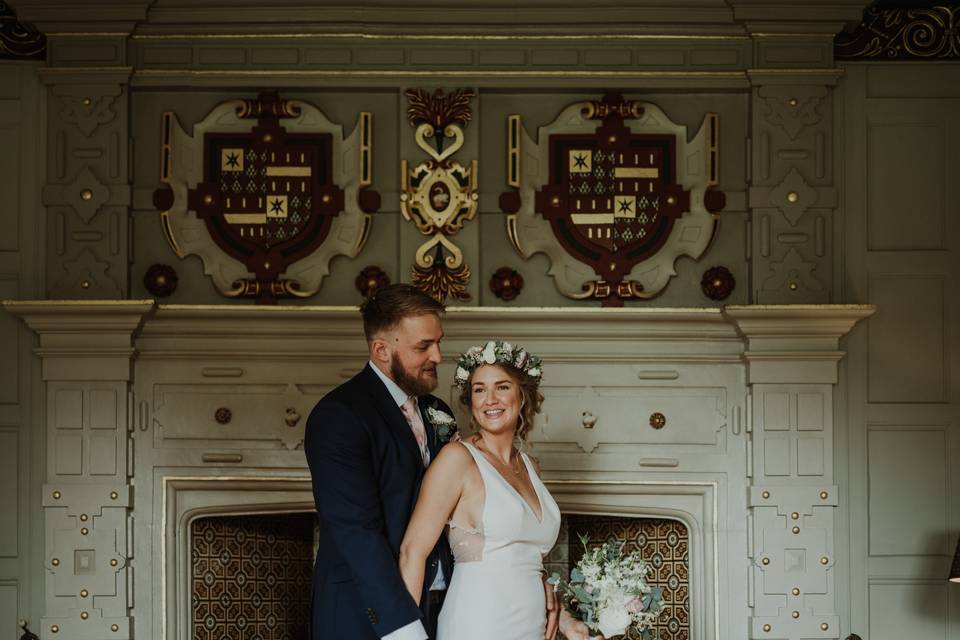 Katherine and David in front of a fireplace at Elmore Court