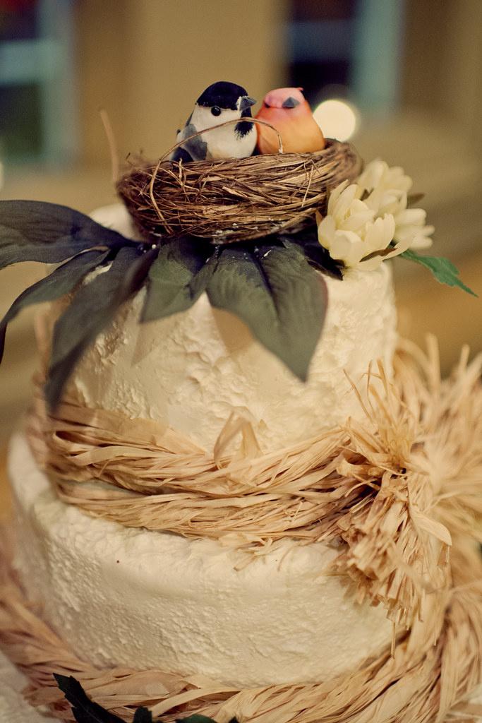 White rustic wedding cake with straw and bird's nest topper