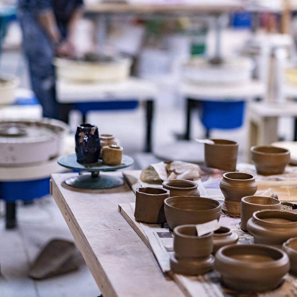 Image of a group of clay pots and pottery wheels showing the inside of the studio