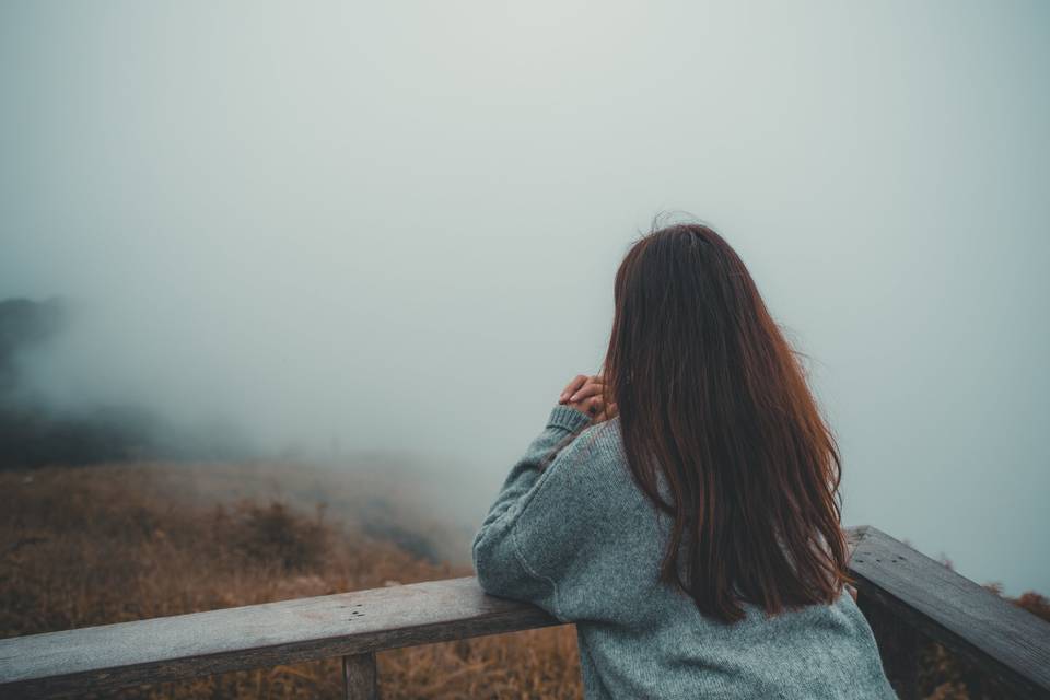 Lonely woman looking out from balcony