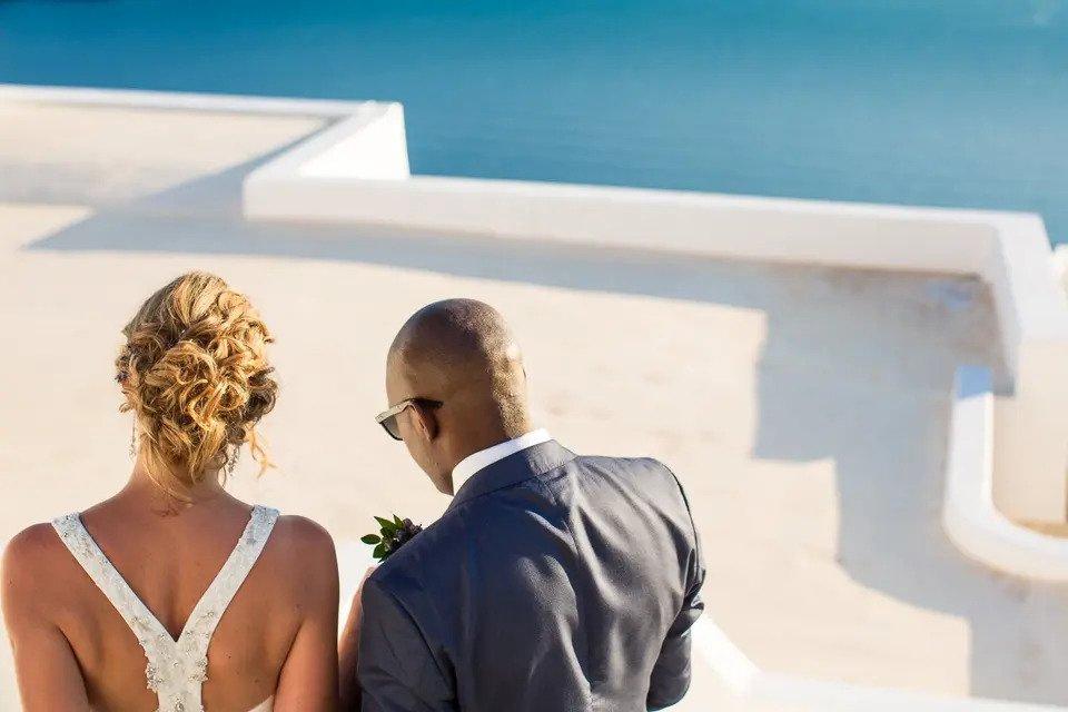 Bride and groom photographed from behind outside a traditional Greek building