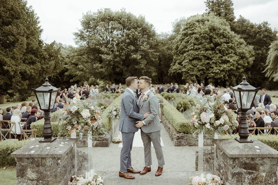 The grooms kiss at the top of the steps