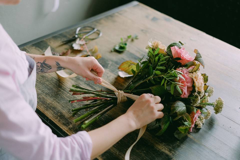 Wedding florist tying flowers