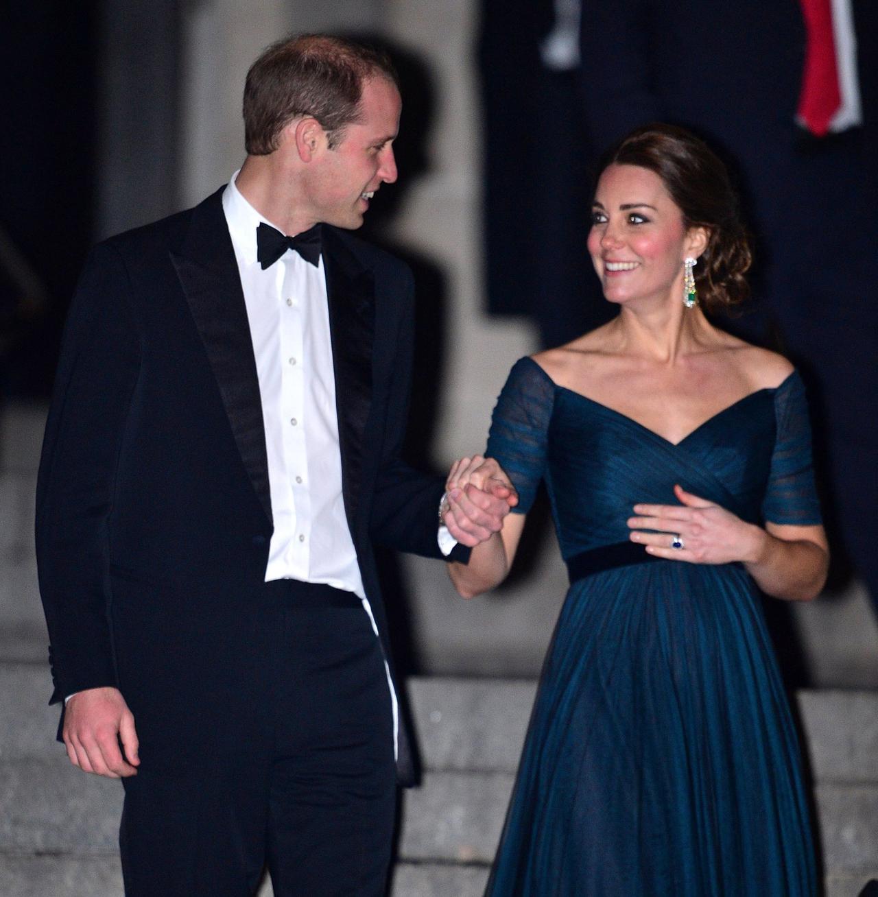 Prince William holds Kate Middleton's hand as they walk down steps