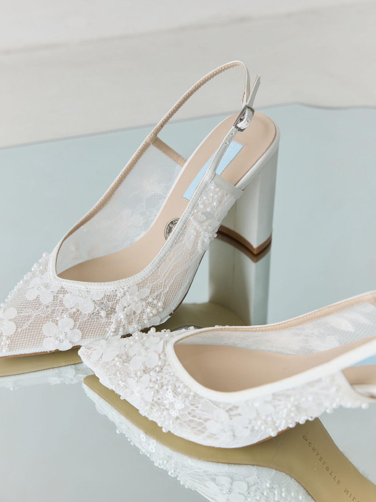 A pair of embellished mesh pointy slingback shoes with block heel on a mirrored surface.