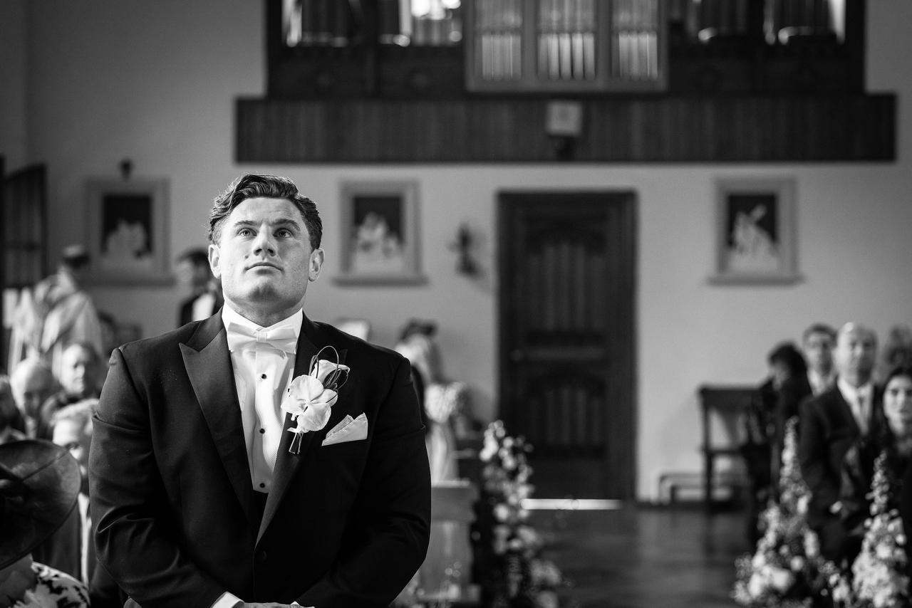 documentary style photograph of wedding day, anxious groom at alter