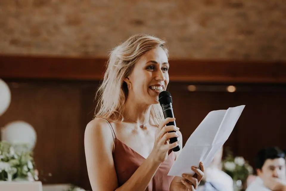 Maid of honour holding a microphone doing a wedding speech