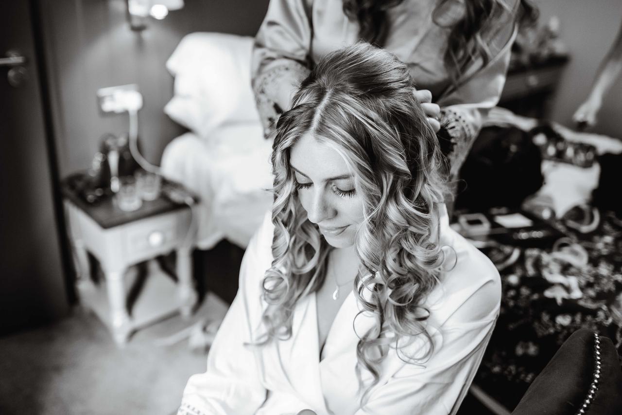 a bride has her hair done on her wedding morning