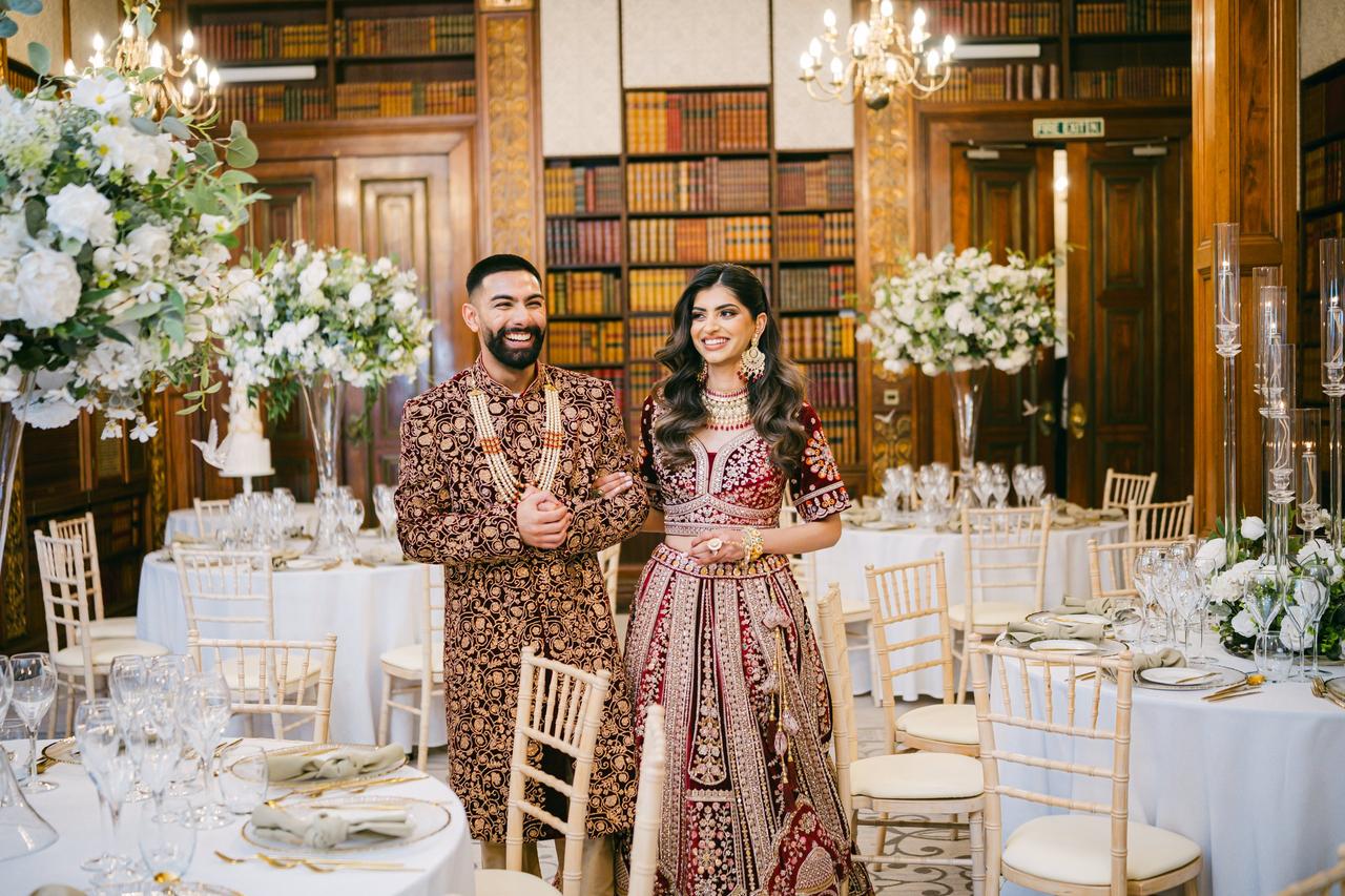 An Indian bride and groom on their wedding day in a great library