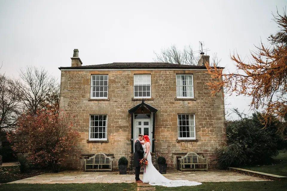 Bride and groom embrace outside a country house wedding venue