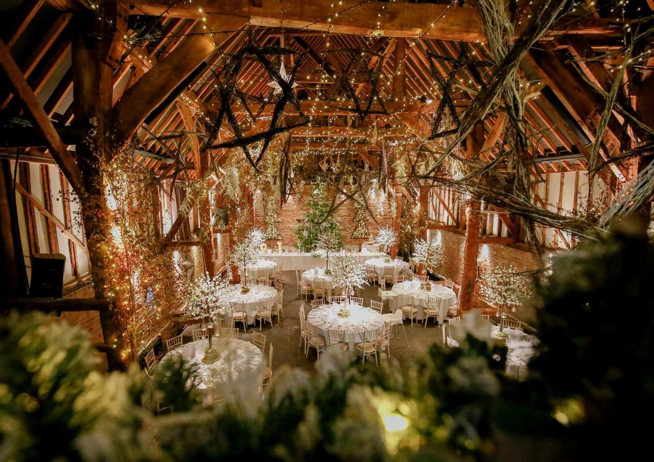 Eaves view of a wood framed barn decorated with fairy lights and set up for a wedding reception