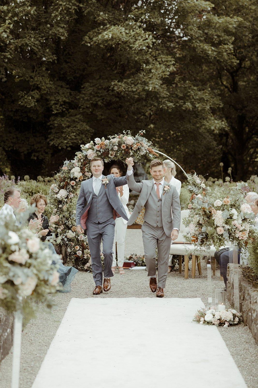 The grooms walk back down the aisle together