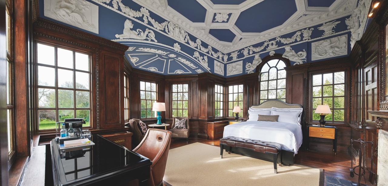 Wood panelled bedroom with an intricate ceiling