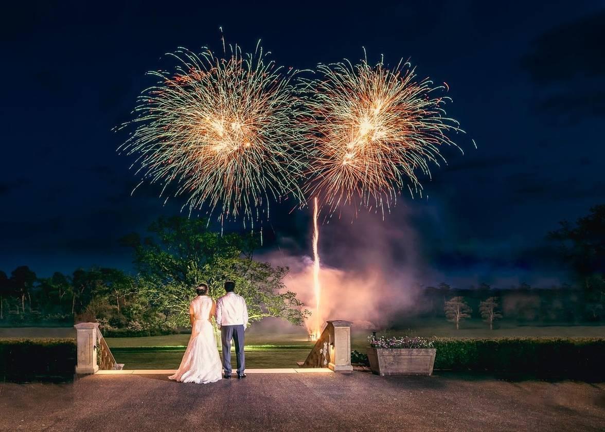 Bride and groom overlooking a firework display