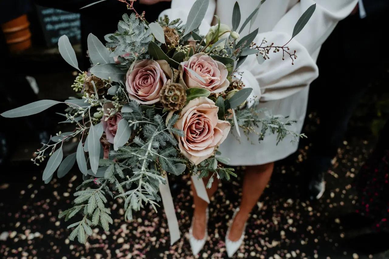 Bride holding a rustic pink rose wedding bouquet