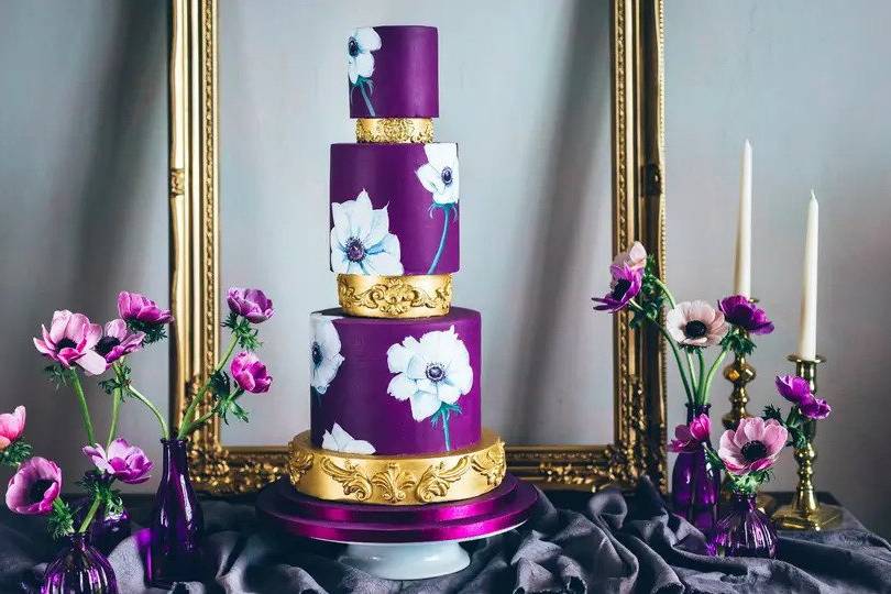 purple and gold wedding cake with glamorous large hand painted flowers