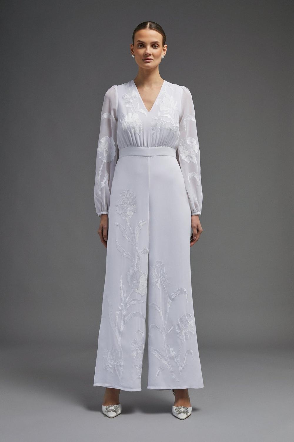Model wearing an embroidered satin wedding jumpsuit