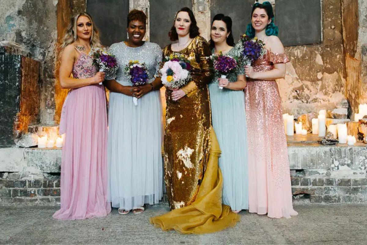 five bridesmaids in stunning alternate coloured bridesmaid dresses in a chapel with candles
