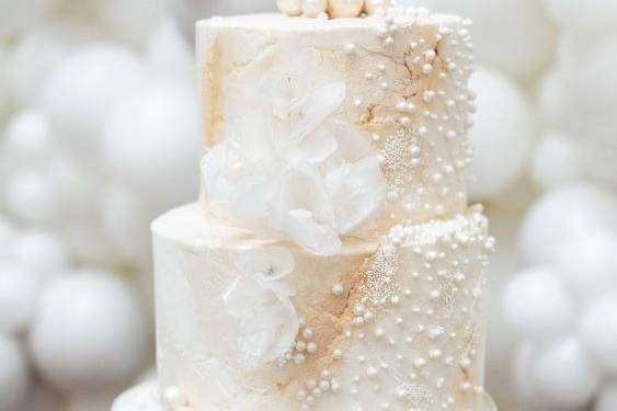 two tiered wedding cake covered with a cascade of edible pearls