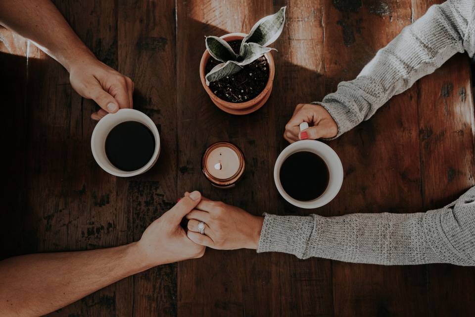 Couple holding hands across the table being physically intimate with each other