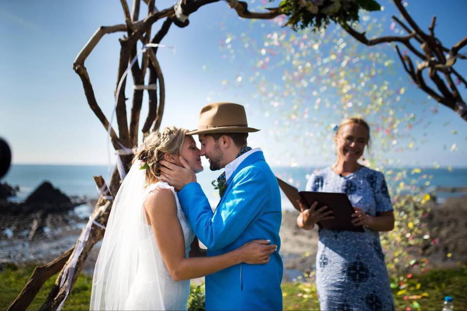 Bride and groom in front of an outdoor altar embracing