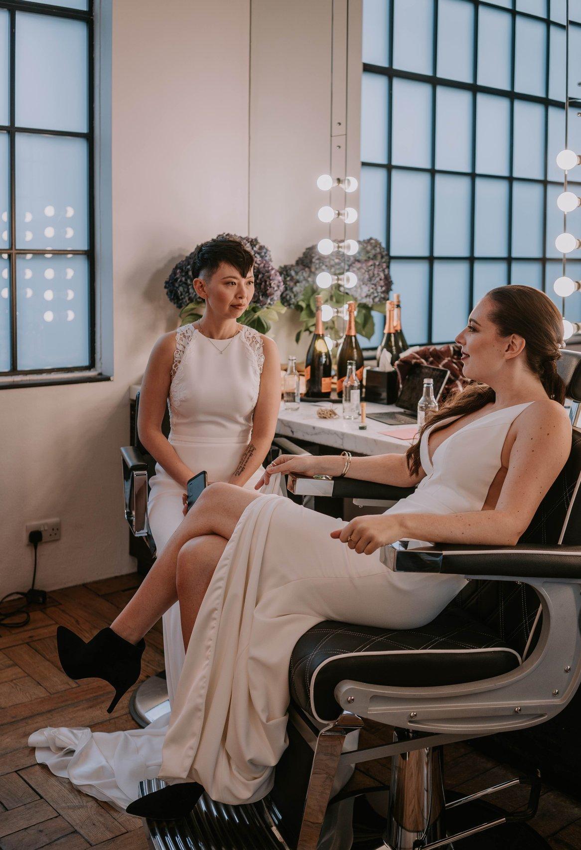 The brides sit chatting in at the dressing table