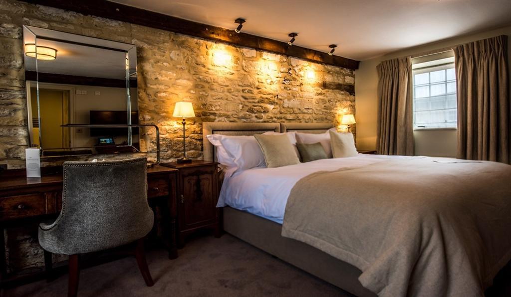 Bedroom at Widbrook Grange with exposed stone wall
