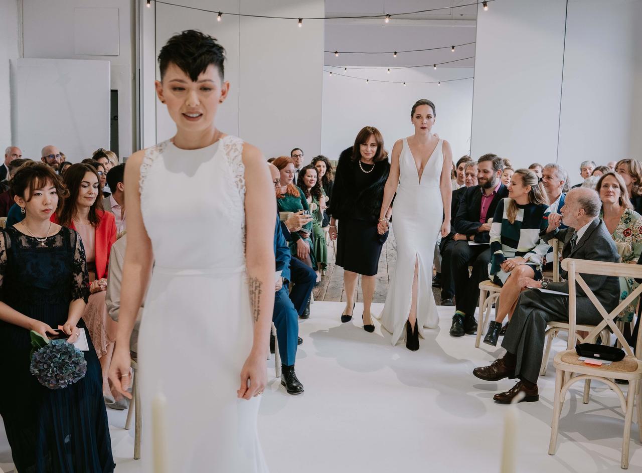 Bride, Phoebe, walks down the aisle with her mum as Misa waits