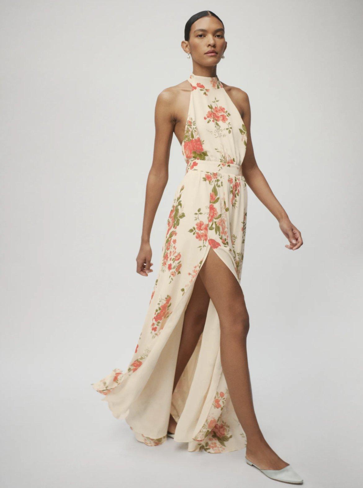 Image of a model wearing a maxi length halterneck dress with a floral print