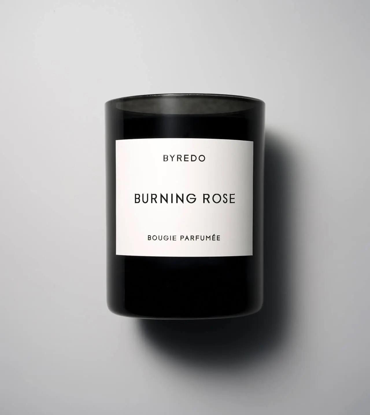 A black candle vessel with a white label that reads 
