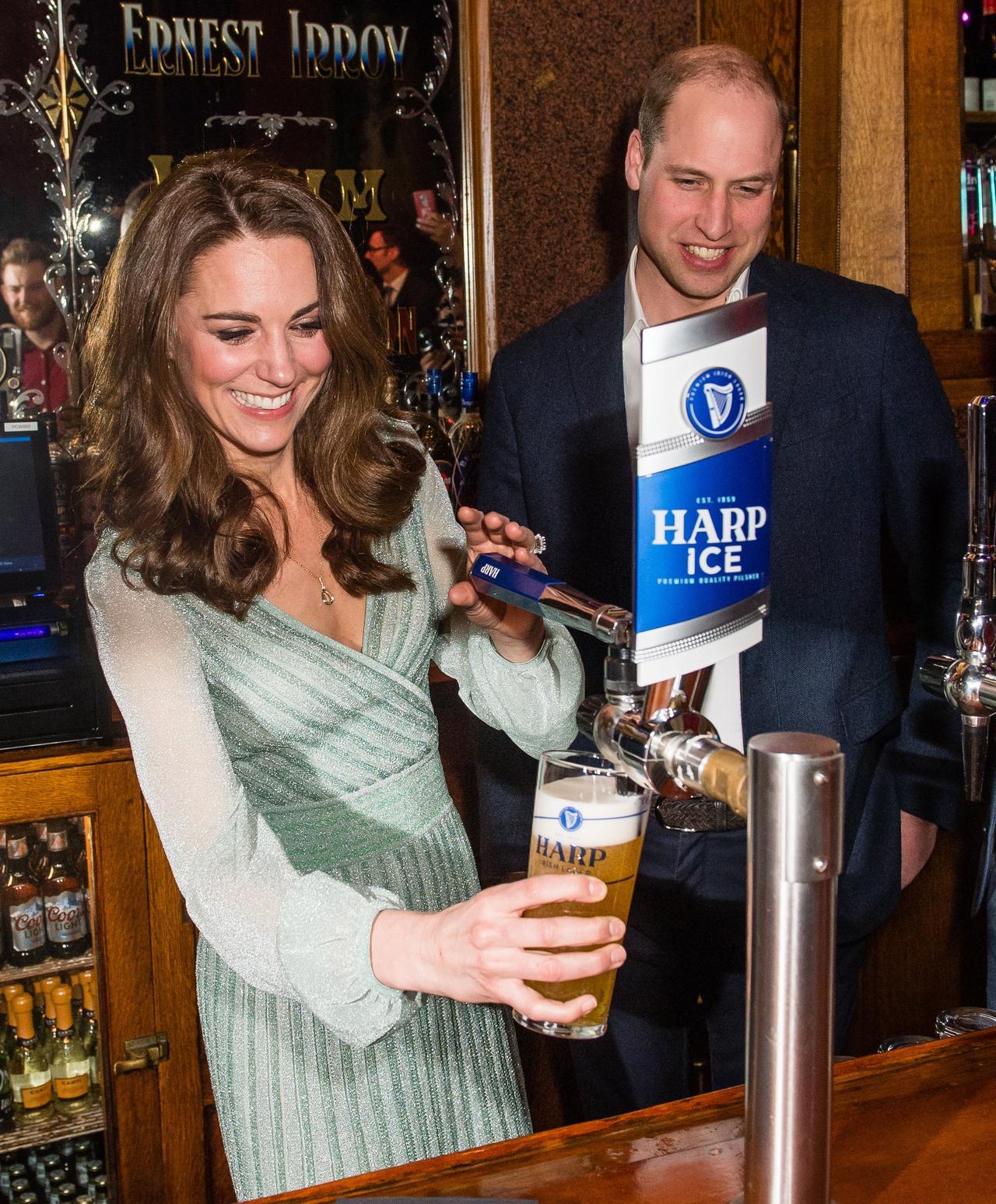 Kate Middleton pulls a pint whilst Prince William looks on