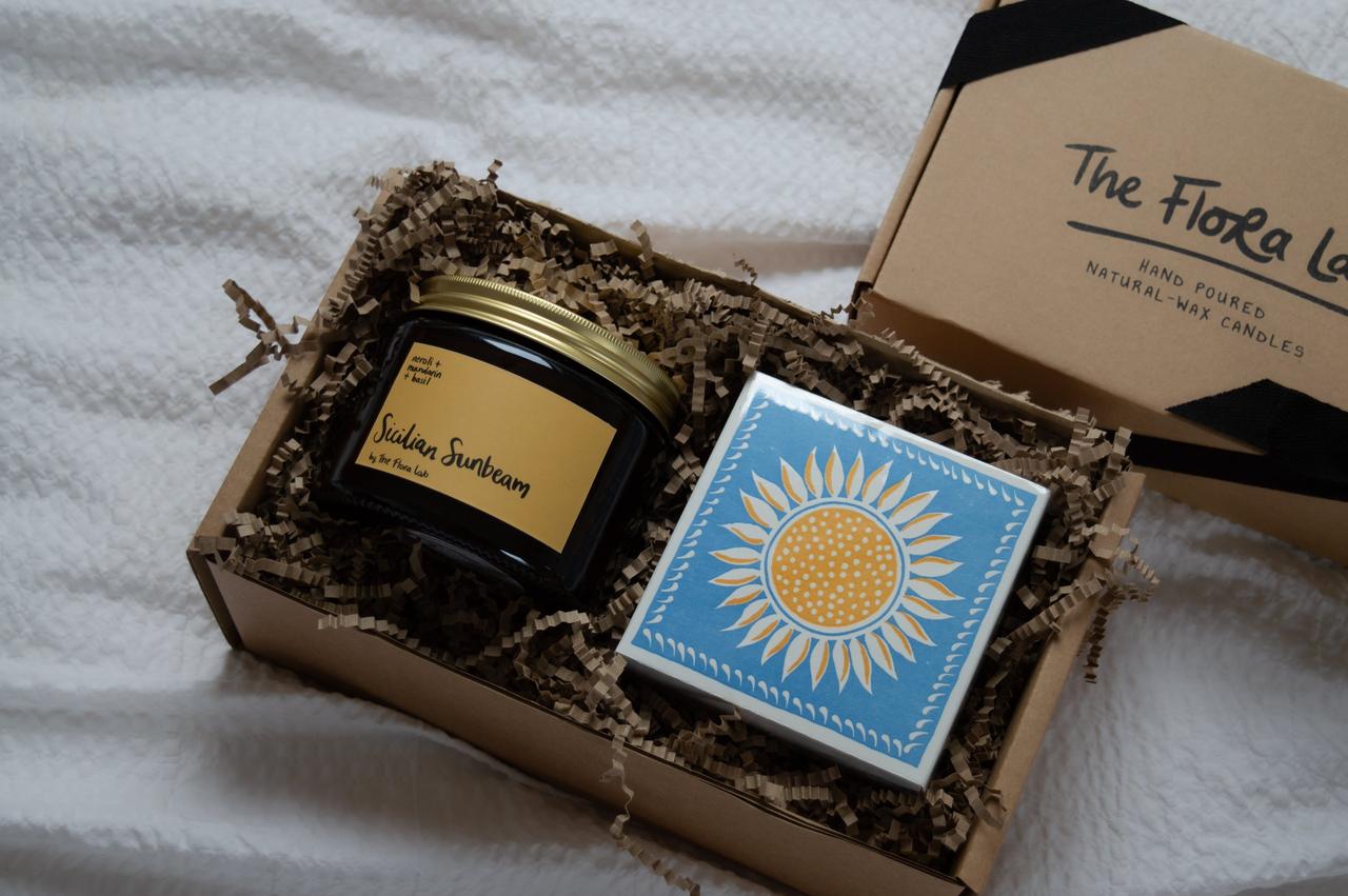 A brown recycled gift box featuring a candle and matches with sunbeam emblem.
