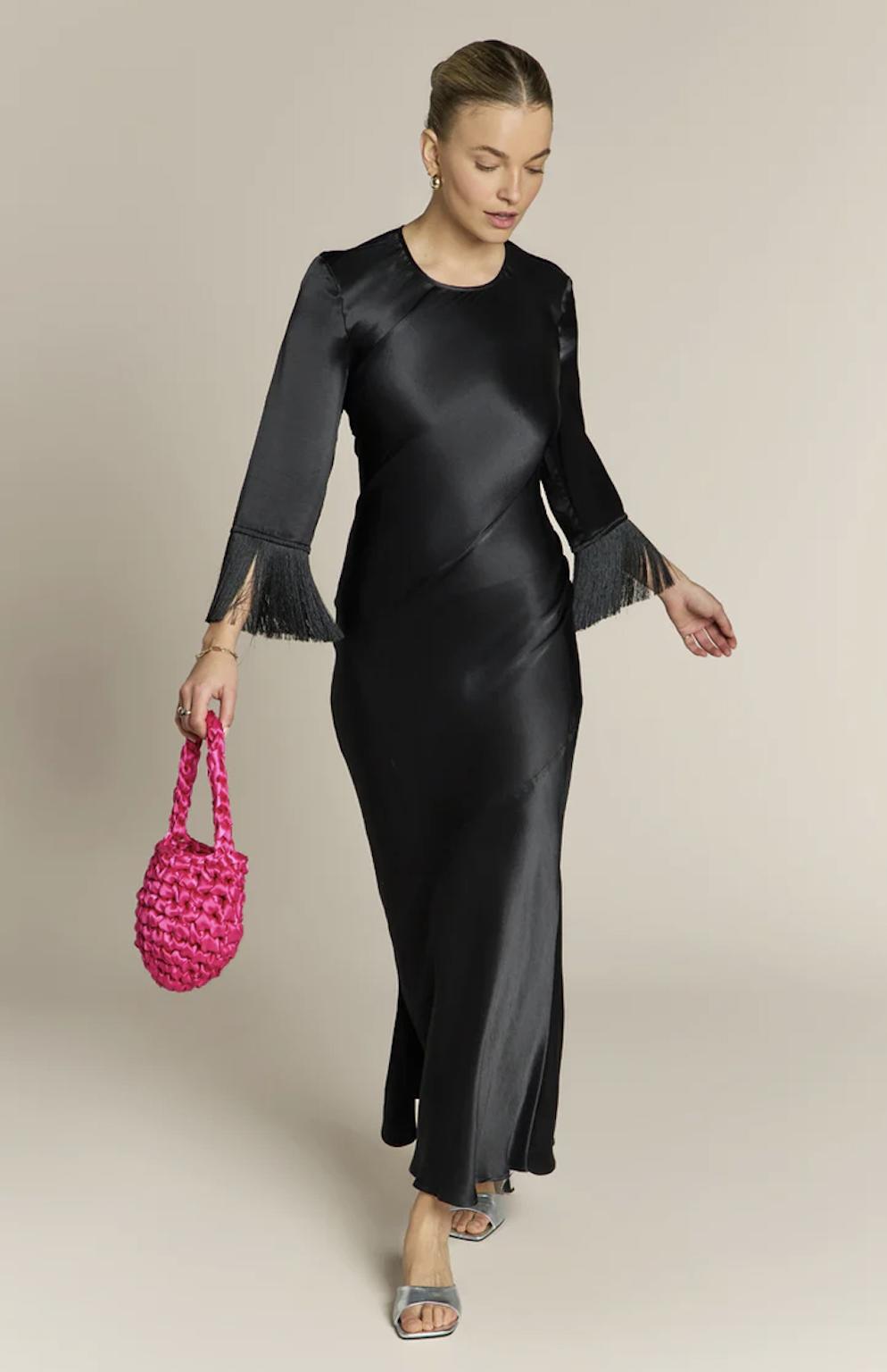 model wearing a black satin long sleeve fringe edge bridesmaid dress