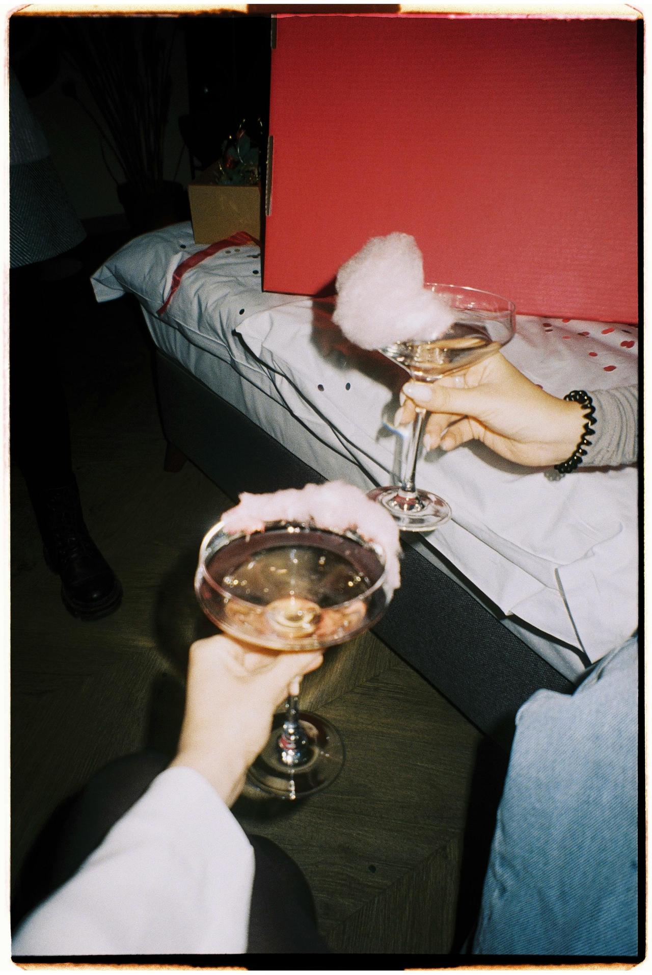 Two champagne coupes with candy floss being cheers together at an at home hen party