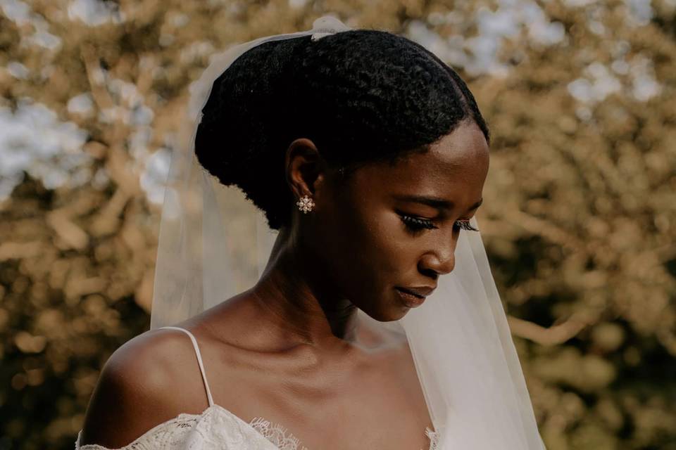 Boho style bride wearing a bohemian wedding dress with spaghetti straps and lace off the shoulder sleeves, holding a bouquet of dried flowers