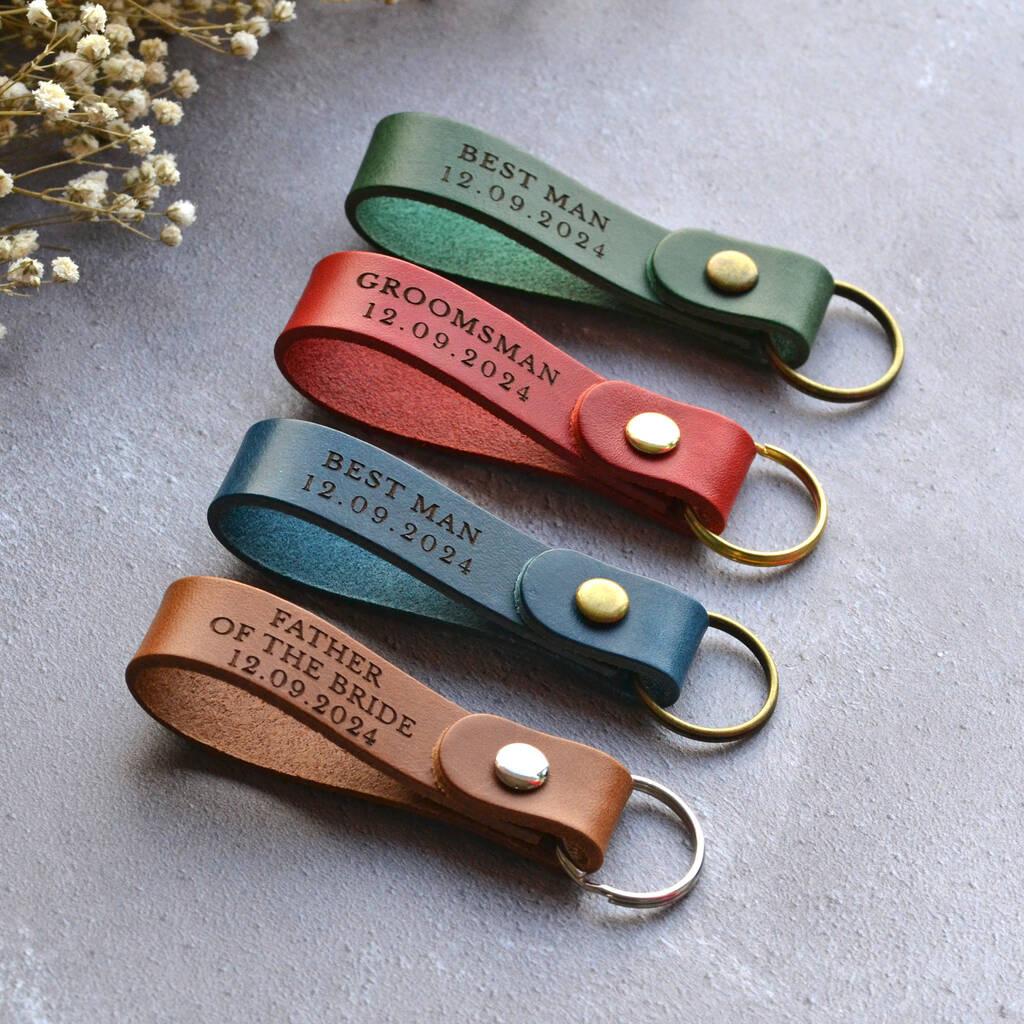 A set of leather keyrings in different colours personalised with wedding party roles, including father of the bride and best man.