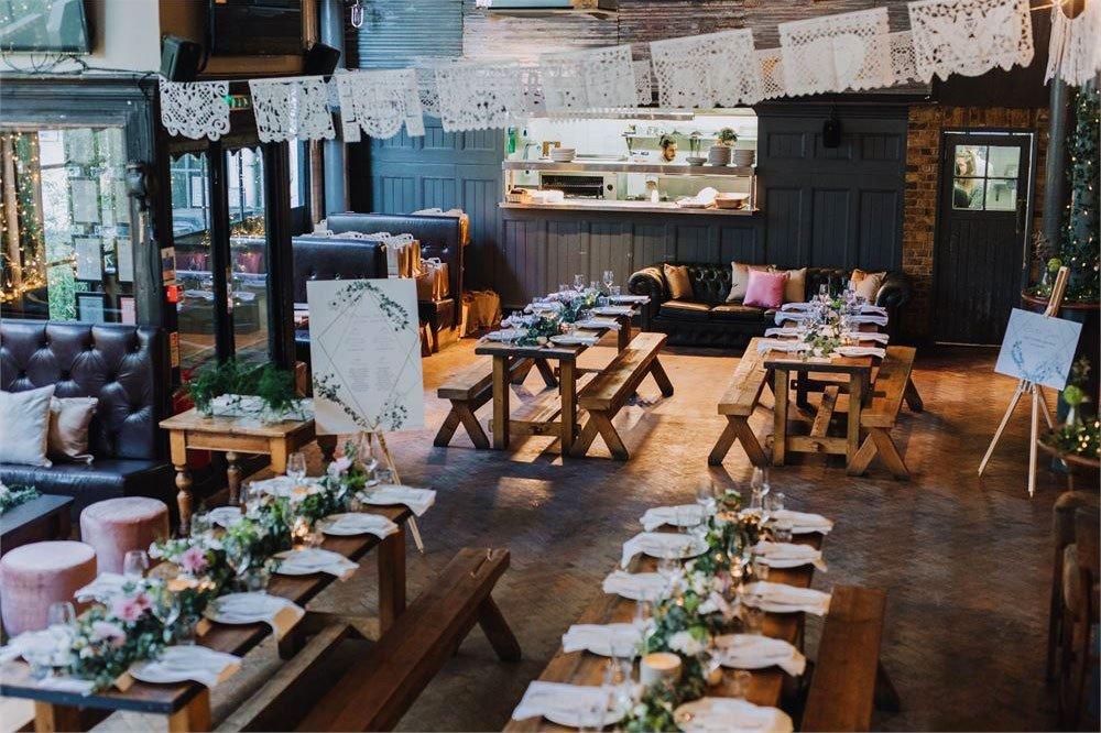 rustic pub wedding venue with wooden benches and lace bunting