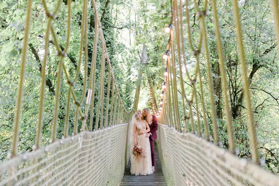 Couple kiss on bridge at The Treehouse